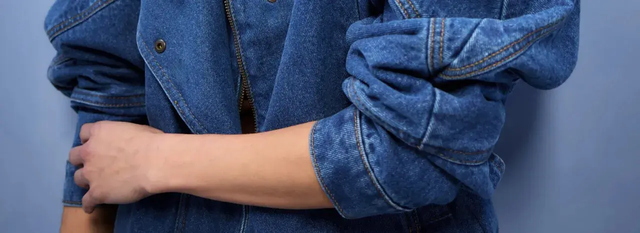 Rękaw kurtki z niebieskiego denimu, zapięcie na zamek błyskawiczny i guzik. To jest właśnie denim!